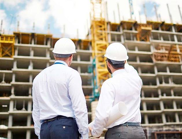 Dos personas supervisando la constucción de un edificio